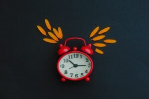 Red alarm clock on a table representing the daylight saving time clock change